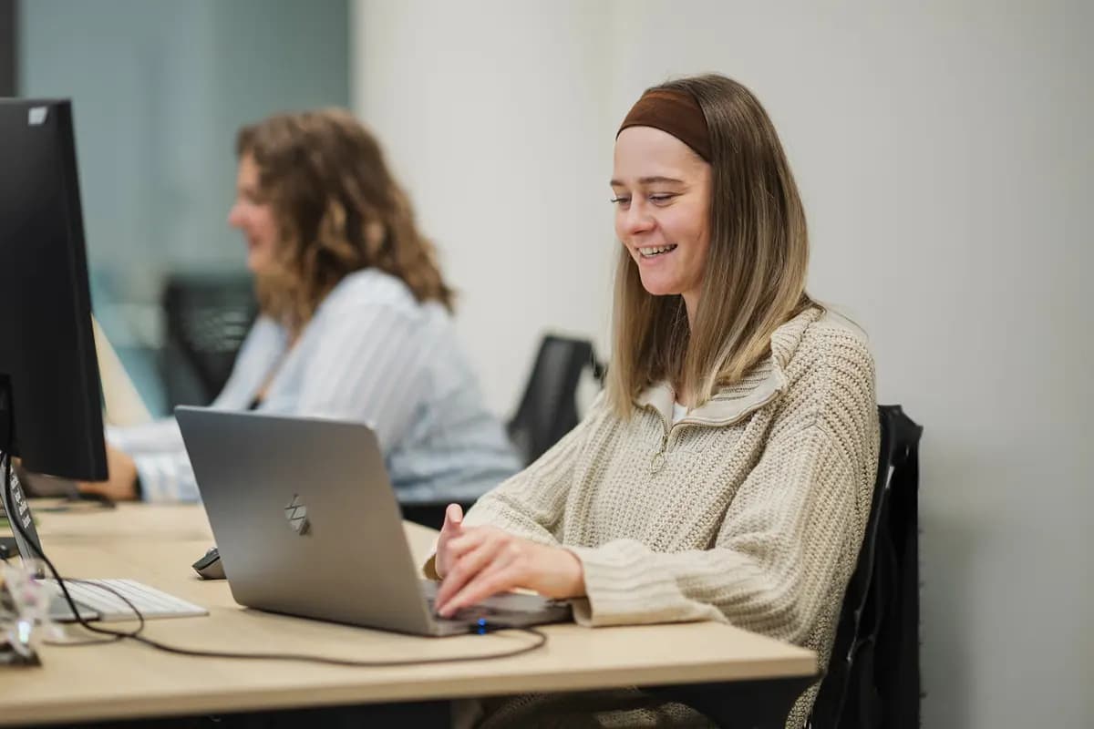 Eine Frau arbeitet im Büro an einem Laptop.